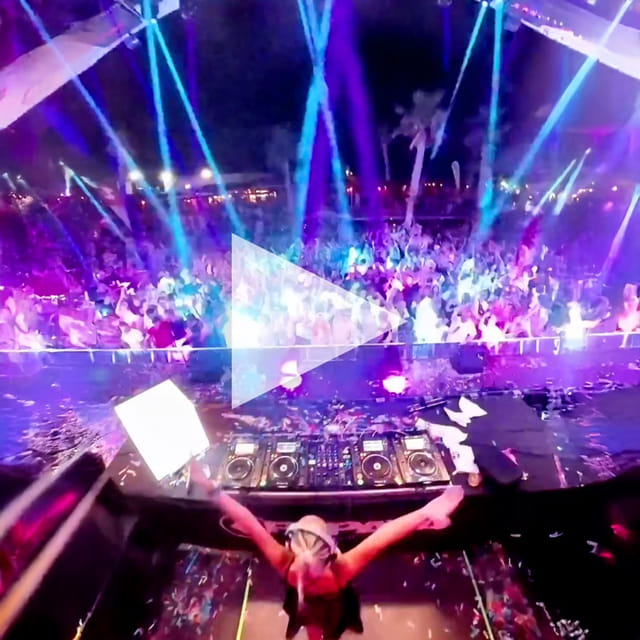 CANDICE stretching both arms toward a packed, confetti-covered club floor from the DJ booth